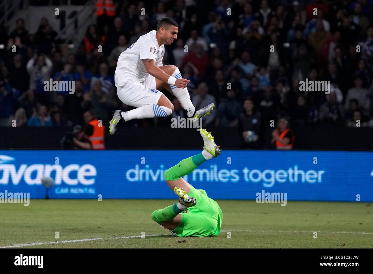 Netherlands' goalkeeper Bart Verbruggen, bottom, makes a save as Greece's Giorgos Giakoumakis jumps over him during the Euro 2024 group B qualifying soccer match between Greece and The Netherlands at the OPAP Arena in Athens, Greece, Monday, Oct. 16, 2023. (AP Photo/Thanassis Stavrakis) Stockfoto