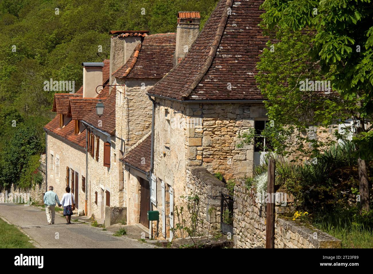 Ein Paar schlendert auf einer steilen Straße, die in die Stadt Rocomadour am Hang im Departement Lot im Südwesten Frankreichs führt Stockfoto