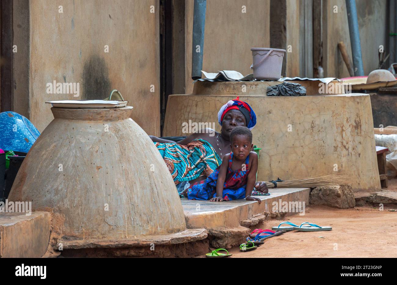 Lome, Togo - 14. Mai 2023. Mutter und Kind beobachten eine Voodoo-Zeremonie aus der Ferne. Stockfoto