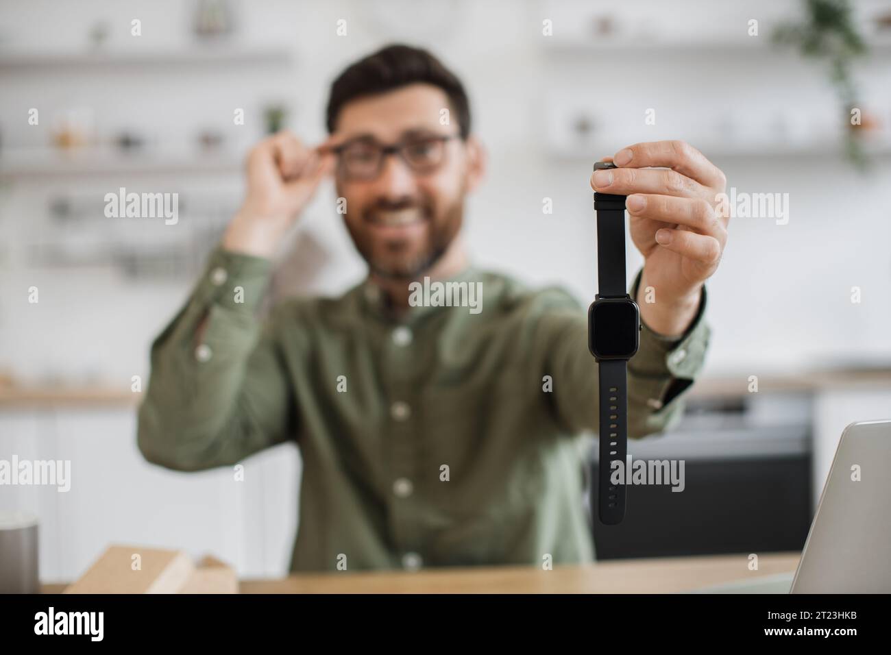 Ein lächelnder Bärenblogger zeigt eine neu gekaufte Smart Watch Stockfoto