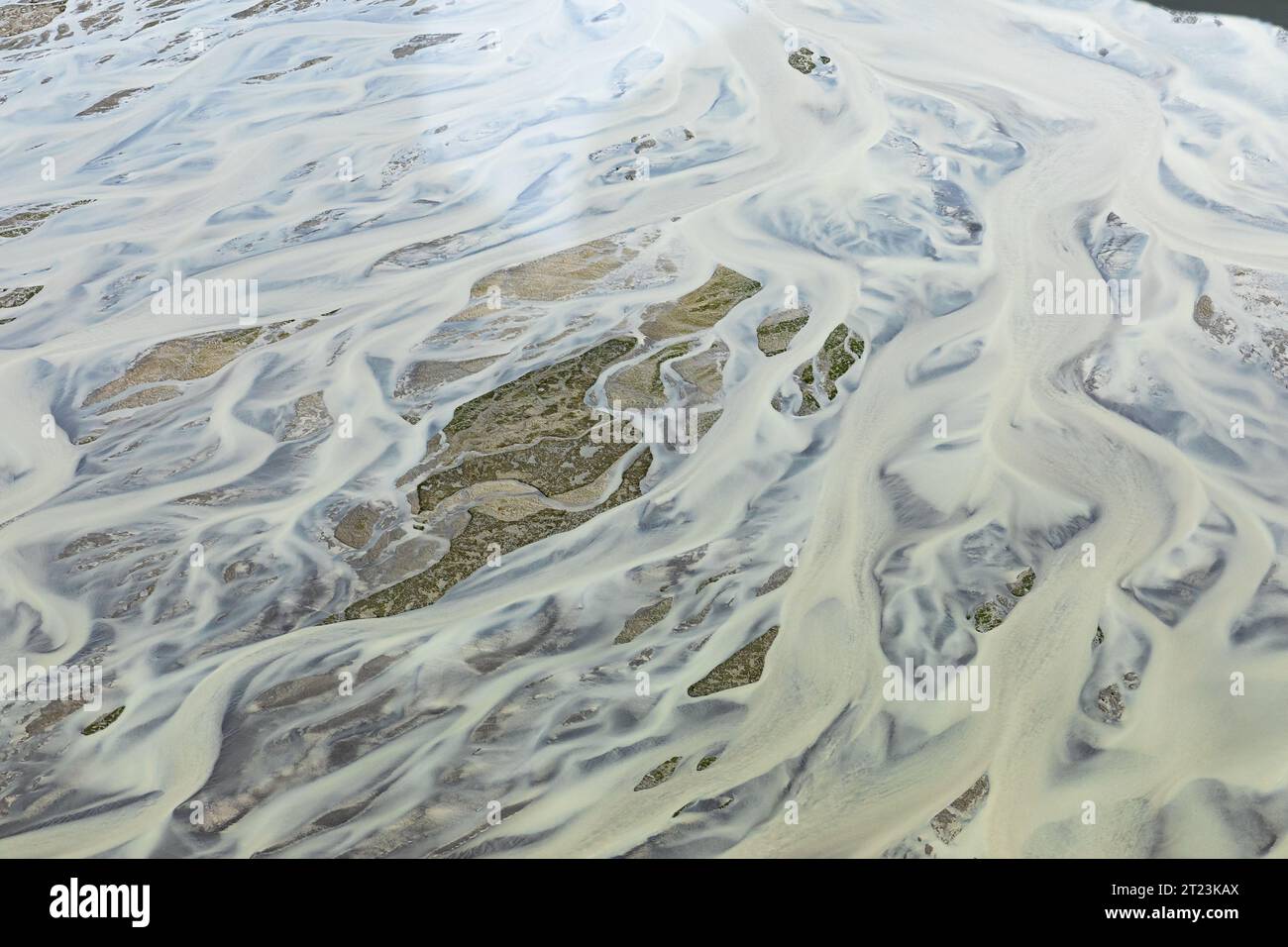 Luftaufnahme der schlammigen Flussmarken, die sich in die Gezeitenbucht ergießen und ein abstraktes Muster bilden Stockfoto