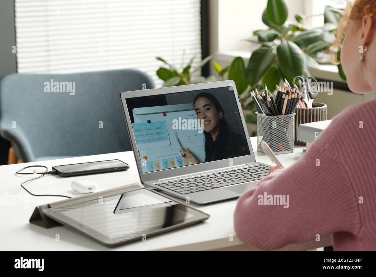Laptop-Bildschirm mit einem jungen erfolgreichen Lehrer der englischen Grammatik, der auf das Whiteboard mit Regeln zeigt und dem Lernenden verschiedene Verben erklärt Stockfoto