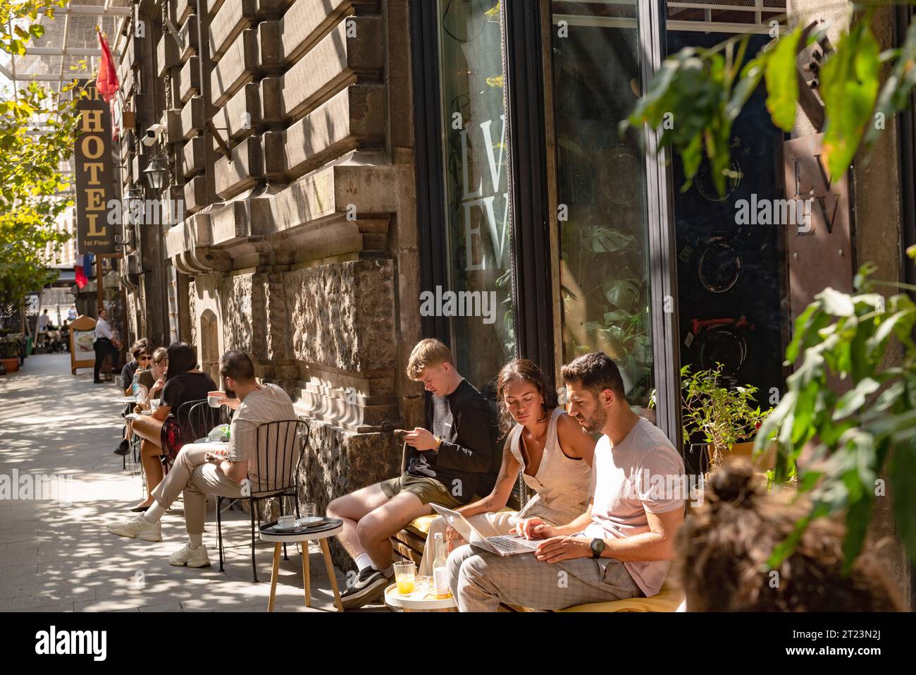 Bukarest, Rumänien. Oktober 2023. Jugendliche entspannen sich vor einem beliebten Café in der Großen Altstadt der rumänischen Hauptstadt Bukarest, Rumänien. Stockfoto