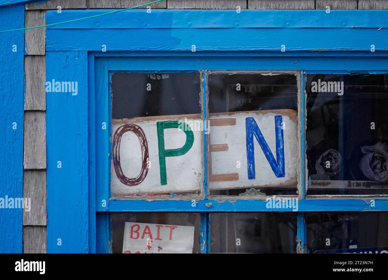 Ich hatte ein "Open"-Schild in einem verwitterten, blauen Fensterrahmen gemacht, der am Menamsha-Teich in Martha's Vineyard, Massachusetts, gefunden wurde Stockfoto