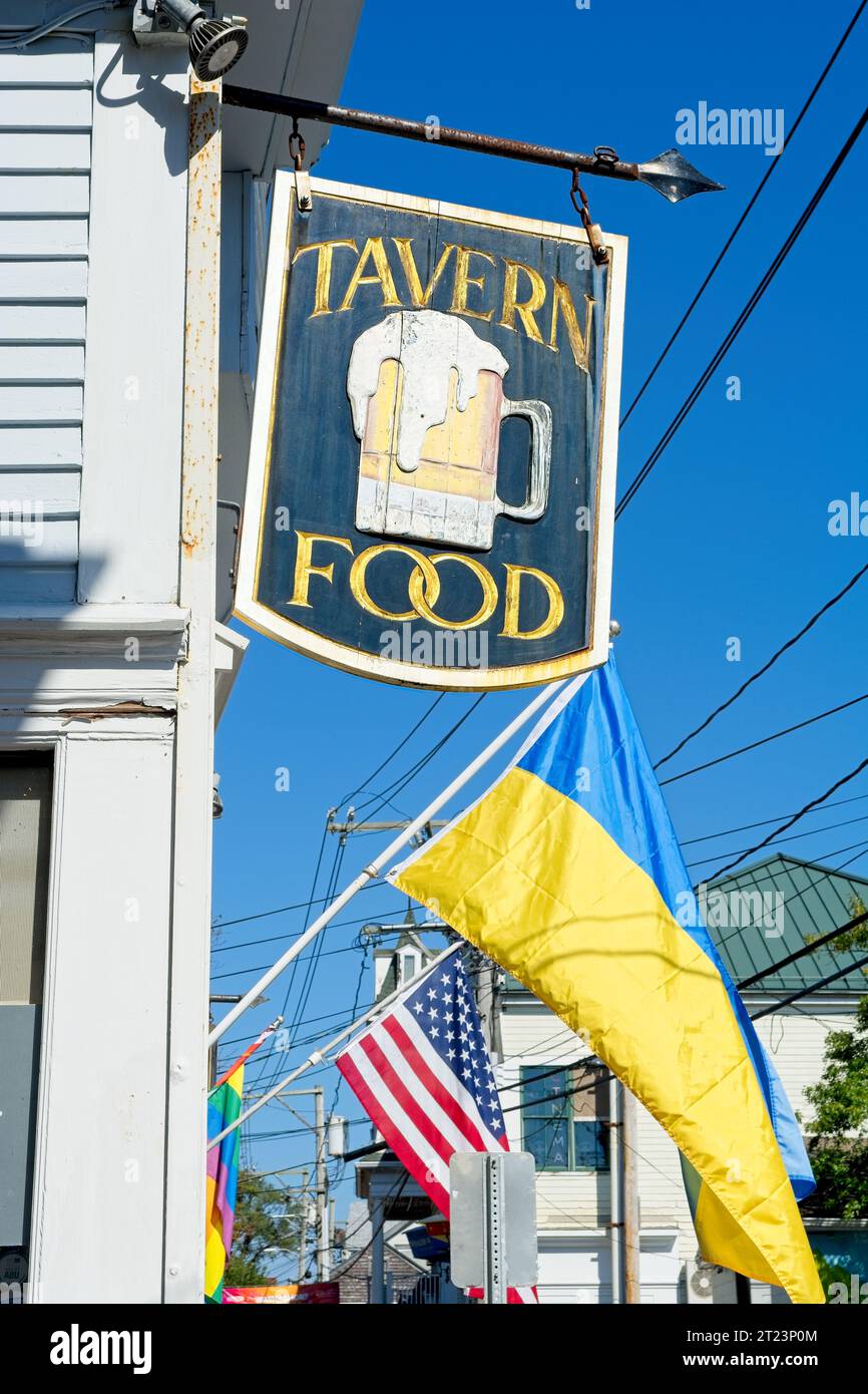 Provincetown, Massachusetts, USA – Oktober 2023: Flaggen und hölzerne Routertafel beschriften das Hotel auf der Handelsstraße in der Innenstadt von Provincetown Stockfoto