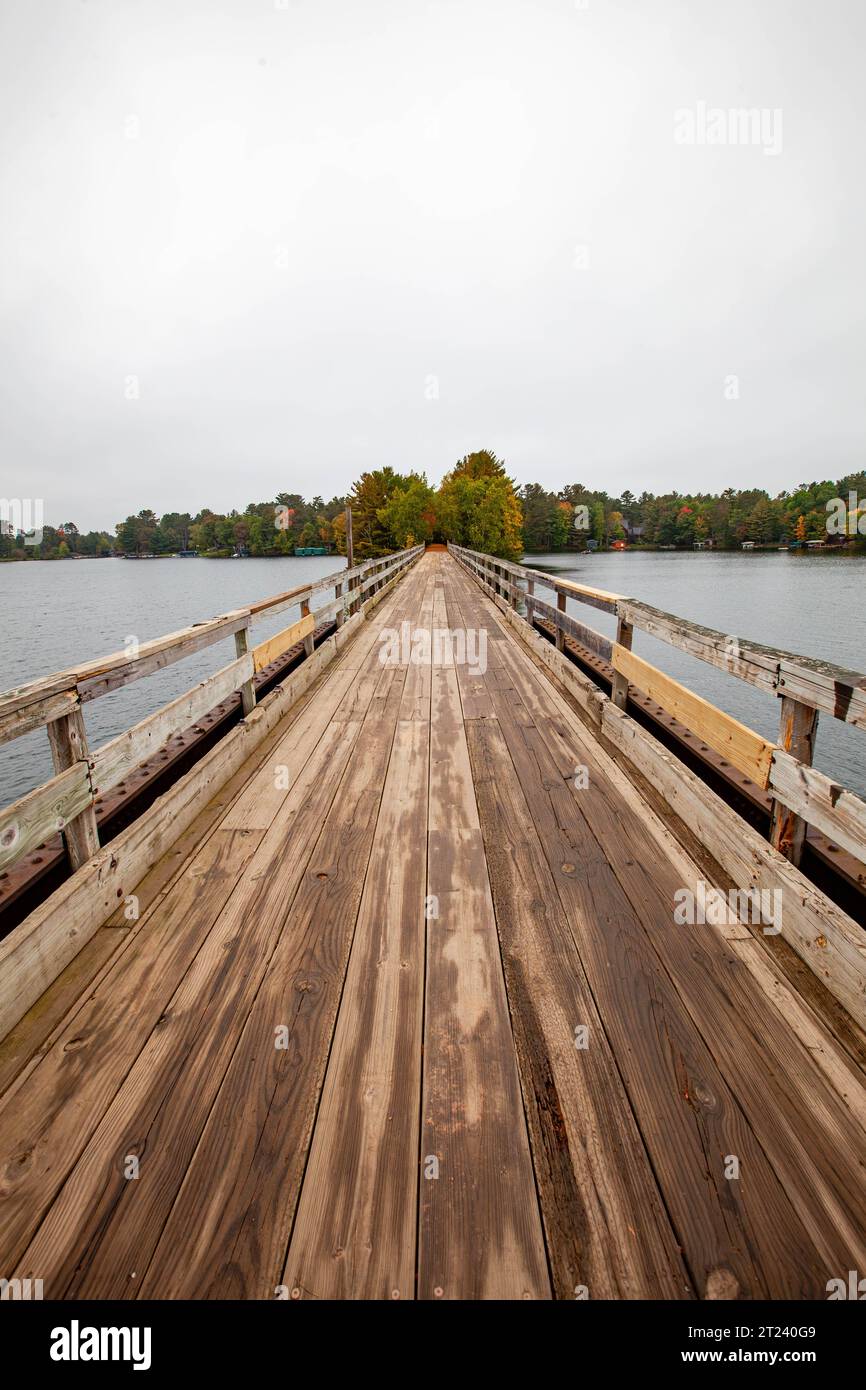 Bearskin Trailhead Bridge in Minocqua, Wisconsin über Lake Minocqua im September, vertikal Stockfoto