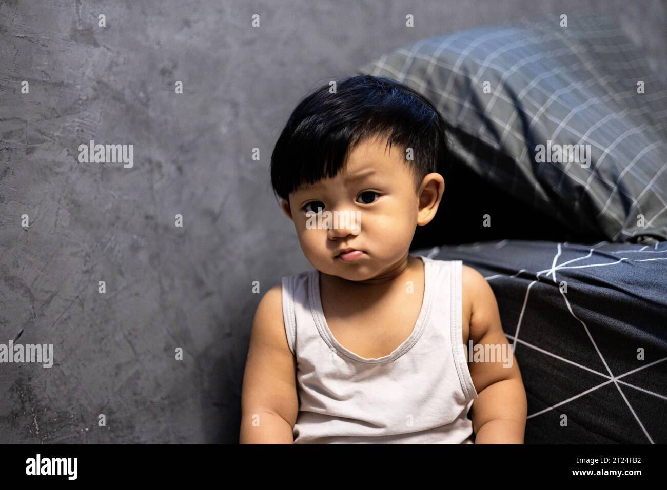 Ein junger asiatischer Junge in seinem Schlafzimmer. Hintergrund für Werbung und Hintergrundbild in der Kinder- und Portraitszene. Tatsächliche Bilder bei Dekorationsideen Stockfoto