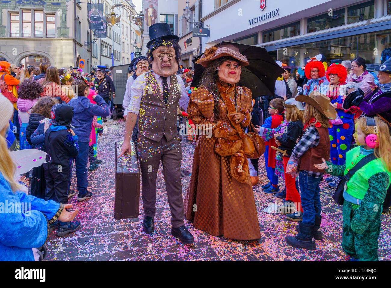Luzern, Schweiz - 21. Februar 2023: Gruppe von Kostümteilnehmern marschiert auf den Straßen, und Menge, Teil der Kinderparade des Fasnac Stockfoto