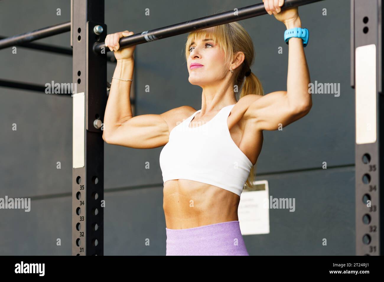 Starke Sportlerin, die Klimmzüge an der Bar macht Stockfoto