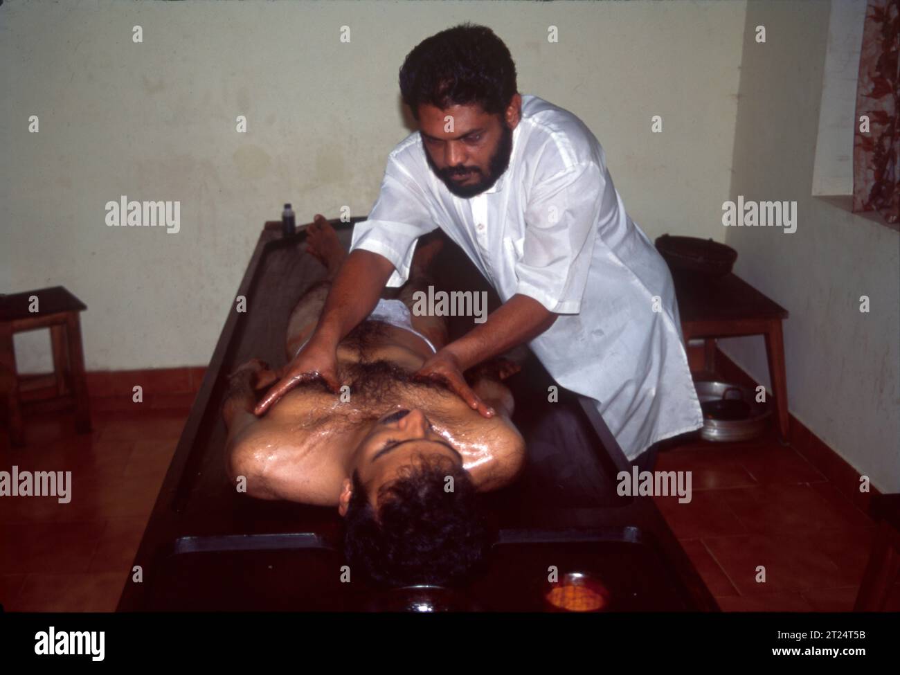 Ayurvedische Ölmassage, Abhyanga ist eine Massage, die mit warmem Öl durchgeführt wird. Das Öl wird auf den gesamten Körper aufgetragen, von der Kopfhaut bis zu den Fußsohlen. Es ist die beliebteste Massage im Ayurveda, ein traditionelles Heilsystem aus Indien. Ayurveda konzentriert sich auf die Erhaltung der Gesundheit durch natürliche Praktiken wie Massage. Kräutermassage hilft, Stress zu lindern, die Durchblutung zu verbessern, Gelenkschmerzen und Entzündungen zu reduzieren, entgiftet, fördert den Schlaf und sorgt für das allgemeine Wohlbefinden. Stockfoto