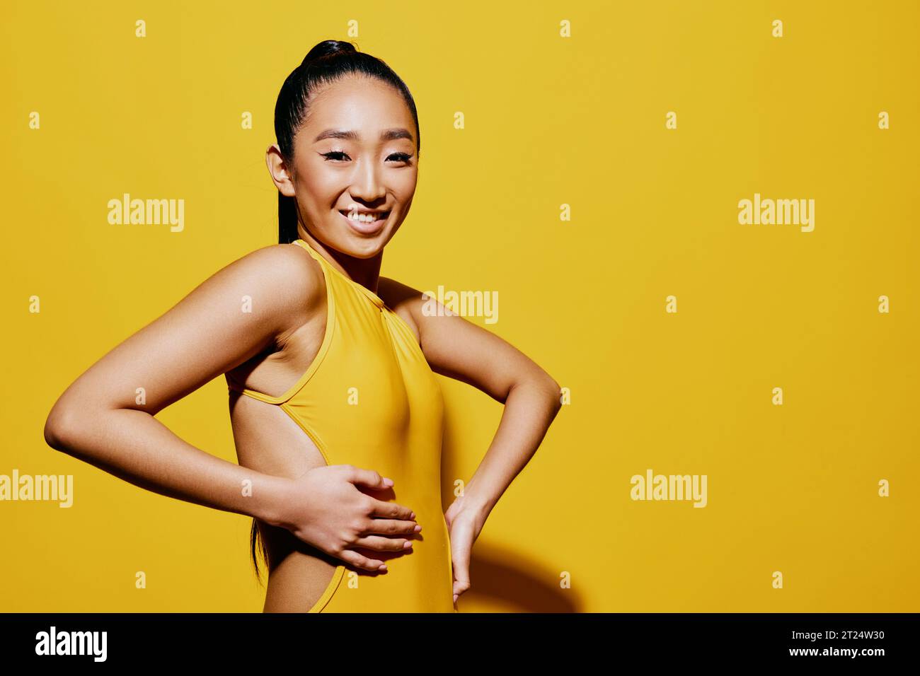 Frau Badeanzug trendy gelb Lächeln Hand Sommer Schönheit überrascht Mode Porträt asiatisch Stockfoto