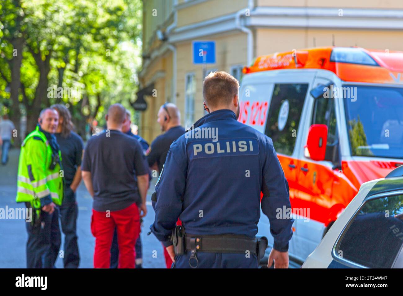 Turku, Finnland – 16. Juni 2019: Ein Polizist auf dem Weg zu einer Gruppe, die sich aus seinem Kollege, Feuerwehrmännern und Sanitätern zusammensetzt. Stockfoto