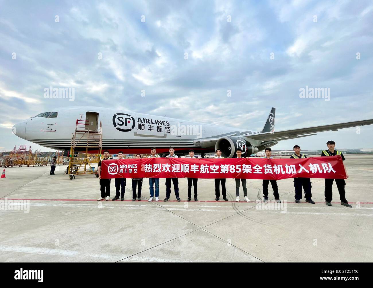 (231017) -- SHENZHEN, 17. Oktober 2023 (Xinhua) -- dieses Foto vom 17. Oktober 2023 zeigt Mitarbeiter, die ein Banner halten, um die Aufnahme des 85. Frachters in die Flotte der SF Airlines am Bao'an International Airport in Shenzhen, der südchinesischen Provinz Guangdong, zu markieren. SF Airlines, Chinas größte Frachtfluggesellschaft in Bezug auf die Flottengröße, hat seine Flotte auf Frachter erweitert, wie die Fluggesellschaft am Dienstag mitteilte. UM MIT „Chinas größter Frachtfluggesellschaft erweitert Frachtflotte auf 85“ (SF Airlines/Handout über Xinhua) zu GEHEN, hat die Fluggesellschaft ihre Flotte auf 85 Frachter erweitert. Stockfoto