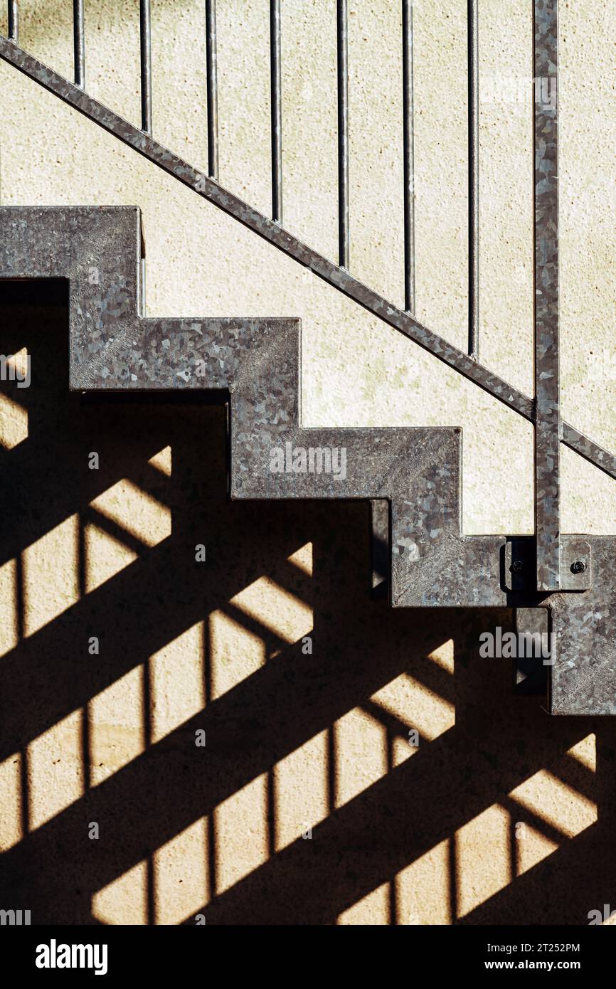 Metallische Treppe und Schatten als abstrakter Hintergrund für Architektur und Geometrie urbanes Muster Stockfoto