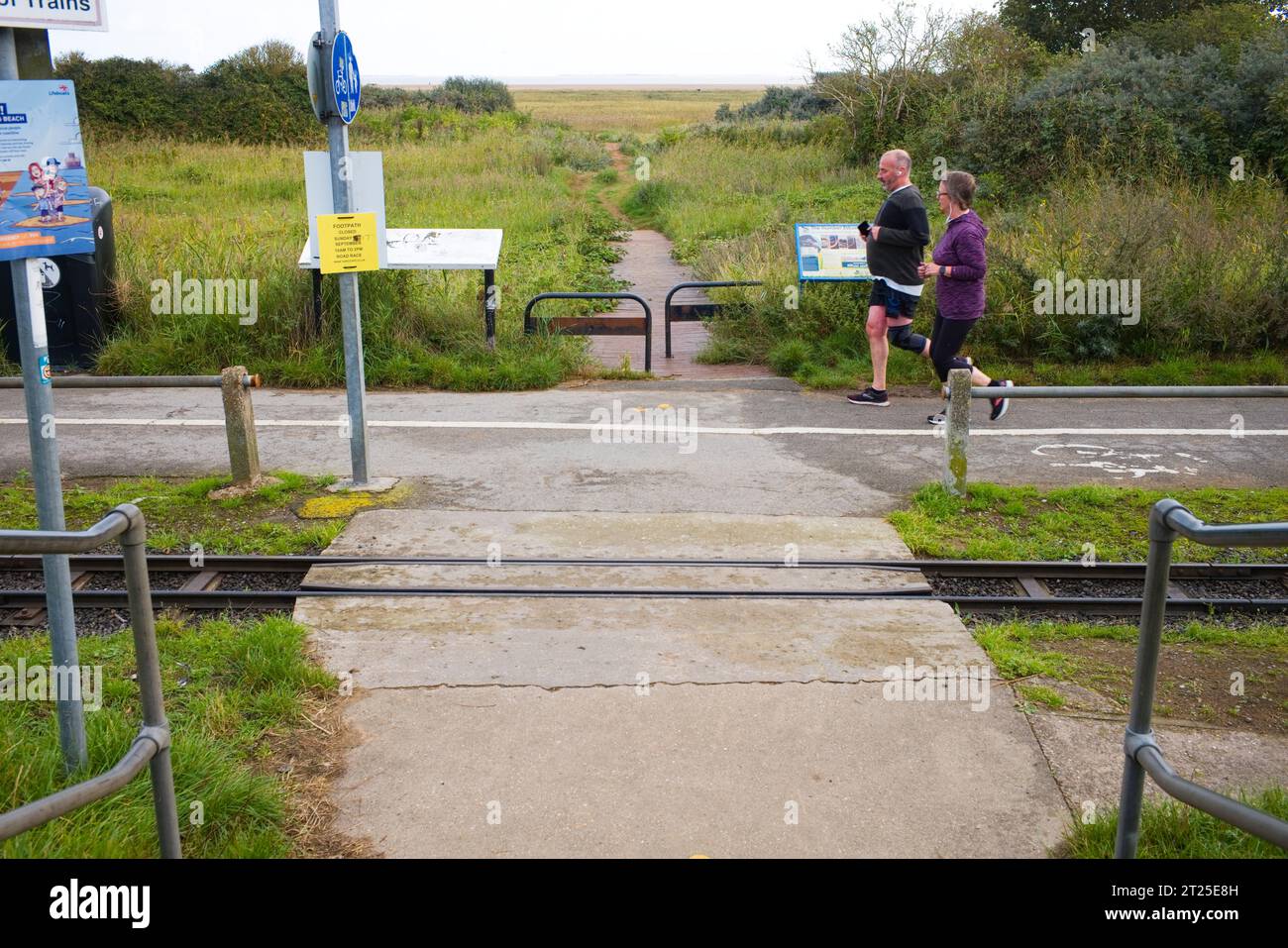 Jogger laufen am südlichen Ende des Cleethorpes Beach Stockfoto