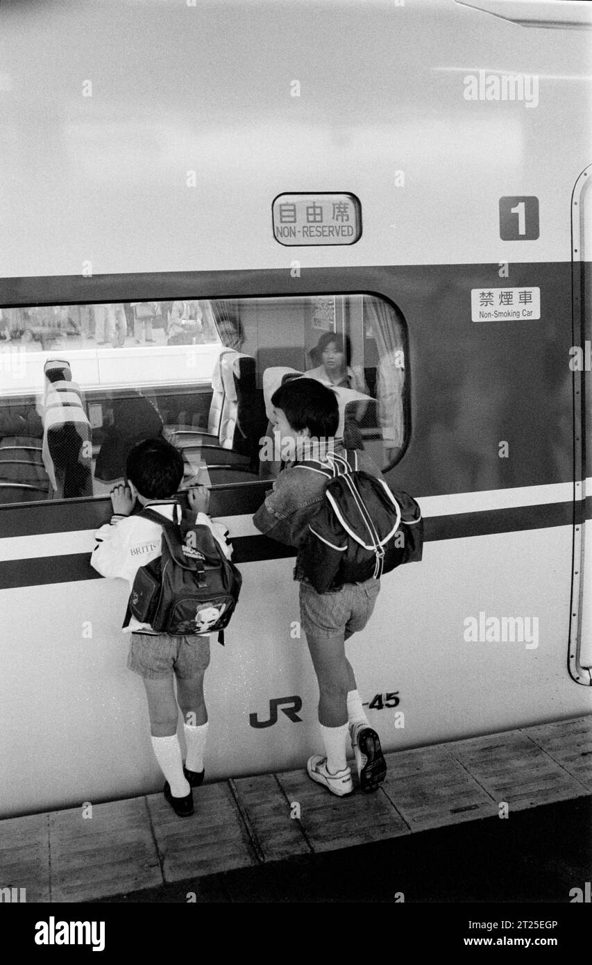 Zwei kleine Jungs vor einem Shinkansen-Zug in Tokio Stockfoto