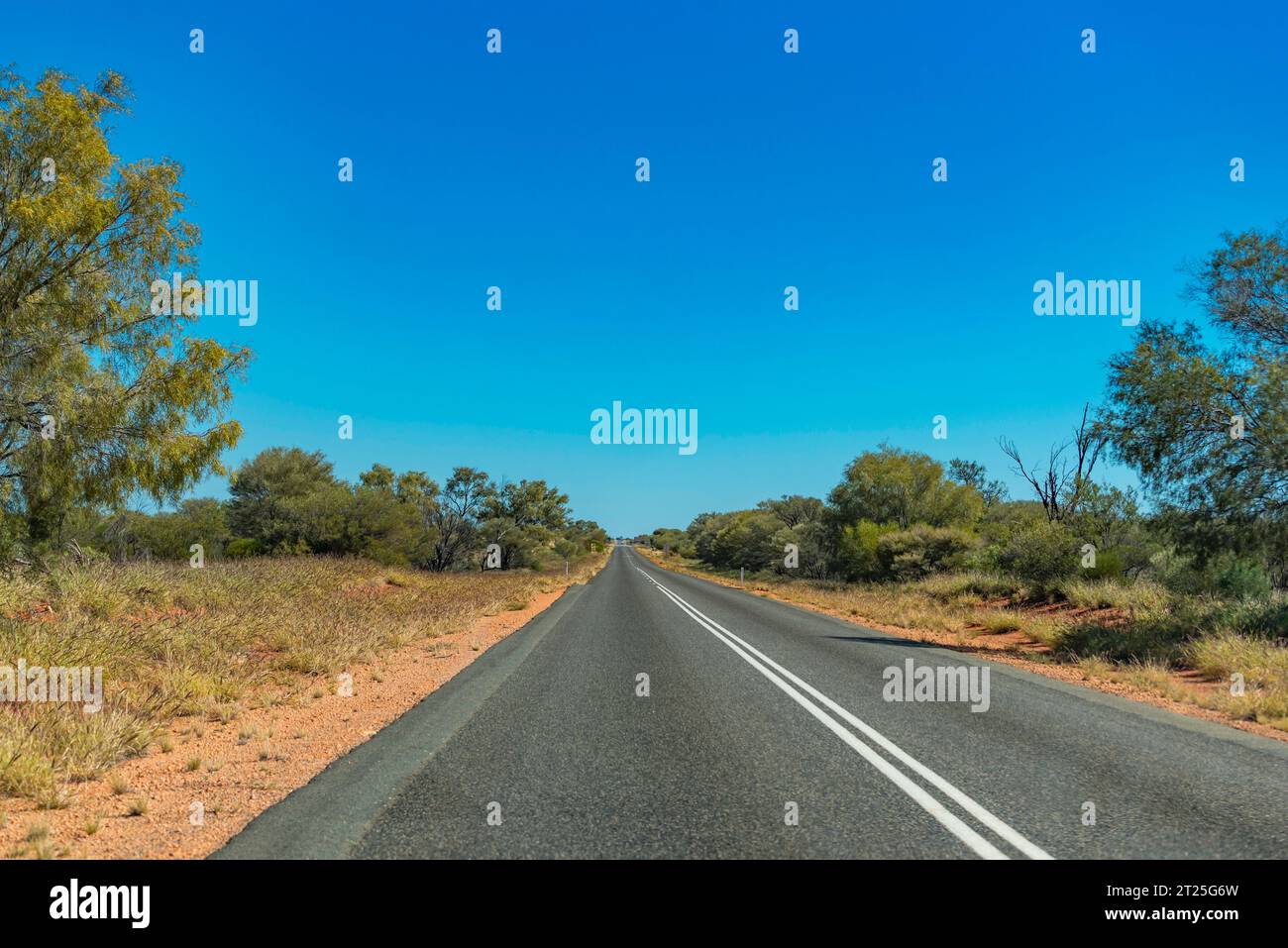 Hitzewolken und eine lange geradlinige Strecke des Lasseter Highway zwischen Alice Springs (Mparntwe) und Kings Canyon im Northern Territory von Australien Stockfoto