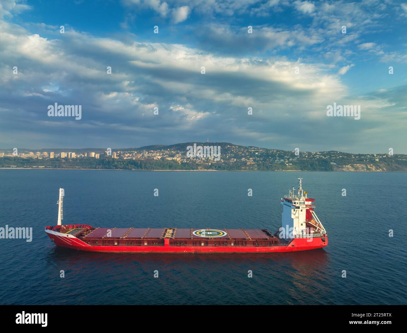 Sonnenaufgang über dem Meereshorizont und Segeln von Industriegutschiffen in tiefblauem, offenem Wasser, aus der Luft Stockfoto