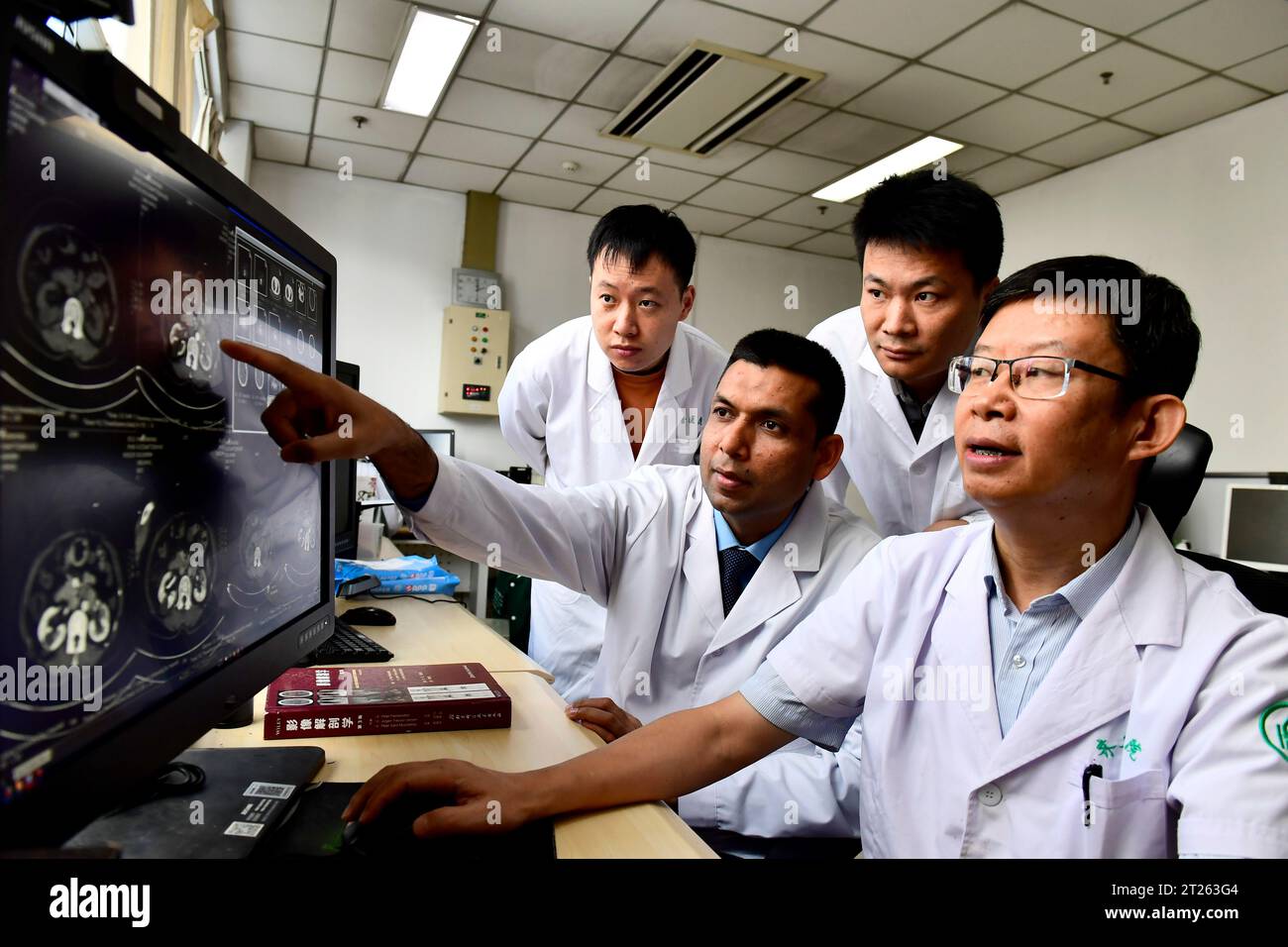 (231017) -- JINAN, 17. Oktober 2023 (Xinhua) -- Muhammed Shahbaz (2. L) arbeitet mit Yu Dexin (1. R), einem Postdoc Supervisor, am Qilu Krankenhaus der Shandong Universität in Jinan, ostchinesische Provinz Shandong, 16. Oktober 2023. Muhammed Shahbaz stammt aus Sargodha, Pakistan. Seit seiner Kindheit träumte Shahbaz davon, denjenigen, die in abgelegenen Gebieten leben und sich keine medizinischen Ausgaben leisten können, eine bessere medizinische Versorgung zu bieten. 2006 schrieb sich Shahbaz an der Shandong University ein. Er erwarb nacheinander Bachelor-, Master- und Doktortitel in Chirurgie, bevor er seinen Postarzt beendete Stockfoto