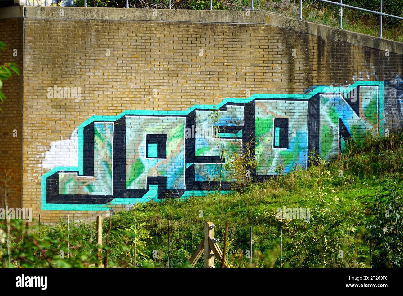 "JASON" Graffiti an der Stützmauer am Bahnhof Ridgmont Stockfoto