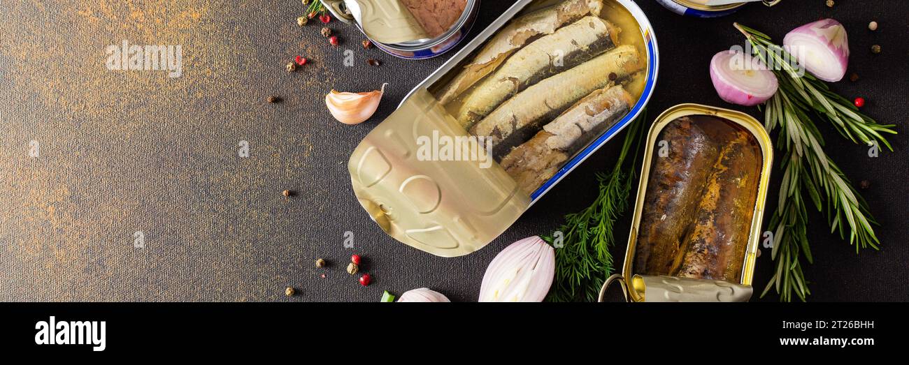 Verschiedene offene Blechdosen mit Fischkonserven unter Gewürz- und Kräuterbanner, Lachs- und Makrelenkonserven, Sprotte und Sardine, Thunfisch und Hering sowie Fischpastete Stockfoto