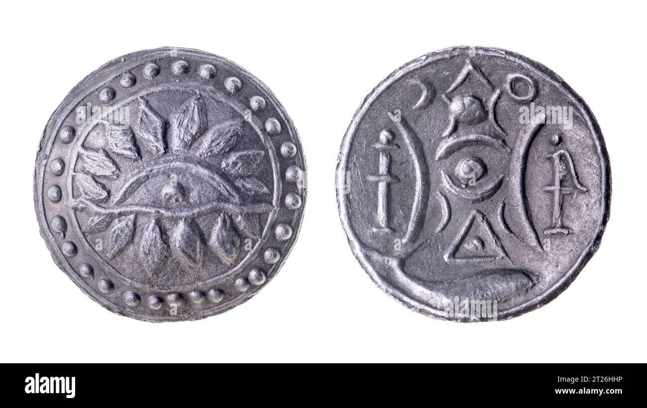 Eine alte Zinnzink-burmesische Münze, die den Sonnenaufgang darstellt. Isoliert auf weiß Stockfoto