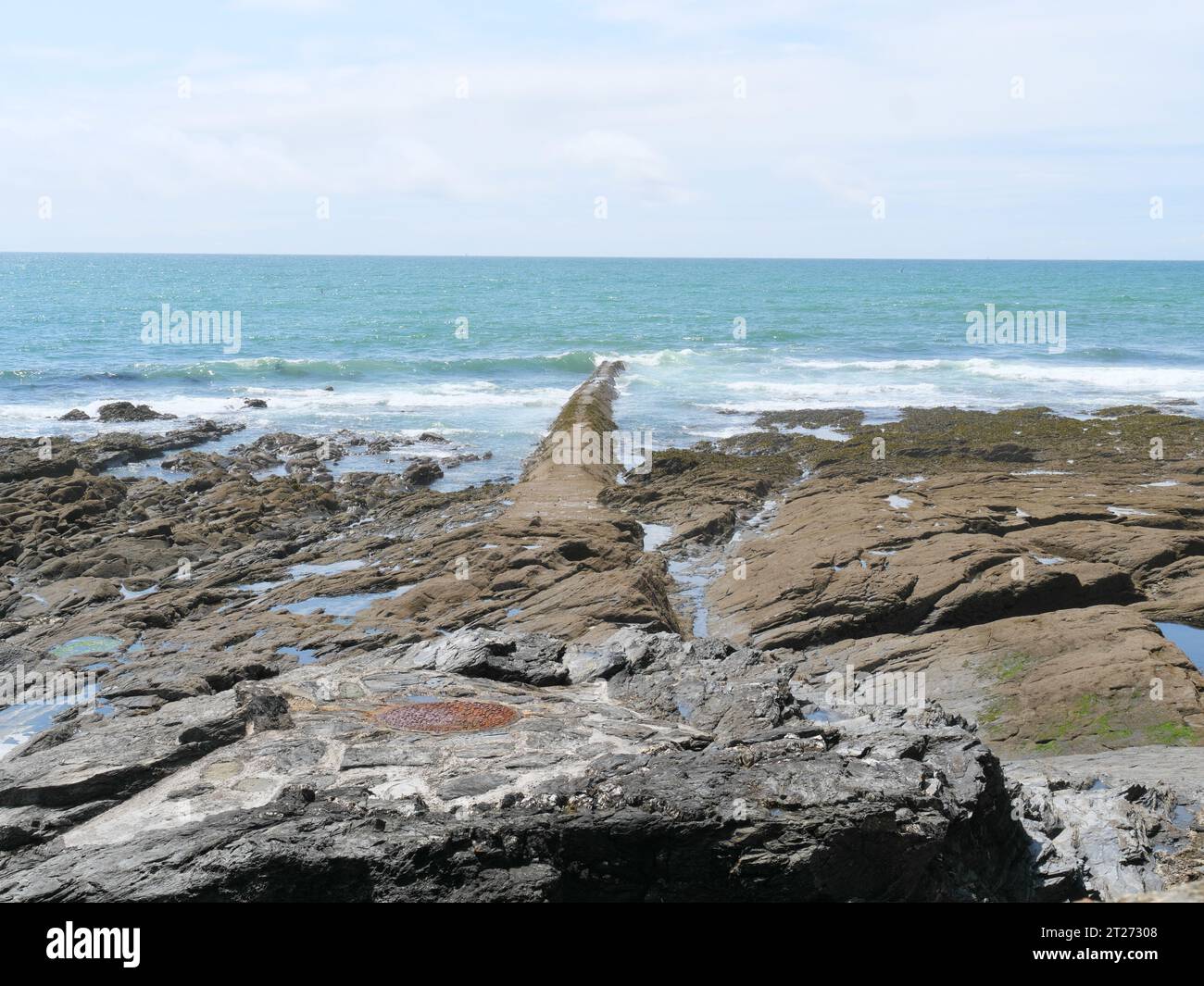 Ein mit Beton bedecktes Abflussrohr führt in das Meer im Hafen von Porthleven in Cornwall England Stockfoto