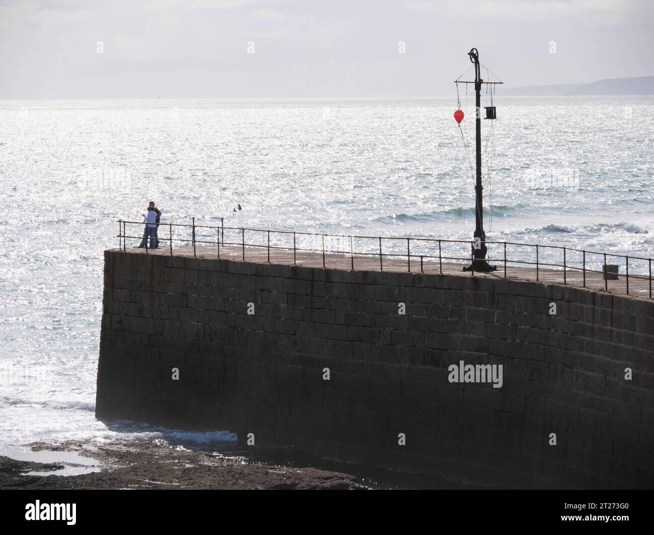 Abendstimmung am Pier mit Signalanlage im Hafen von Porthleven in Cornwall England Stockfoto