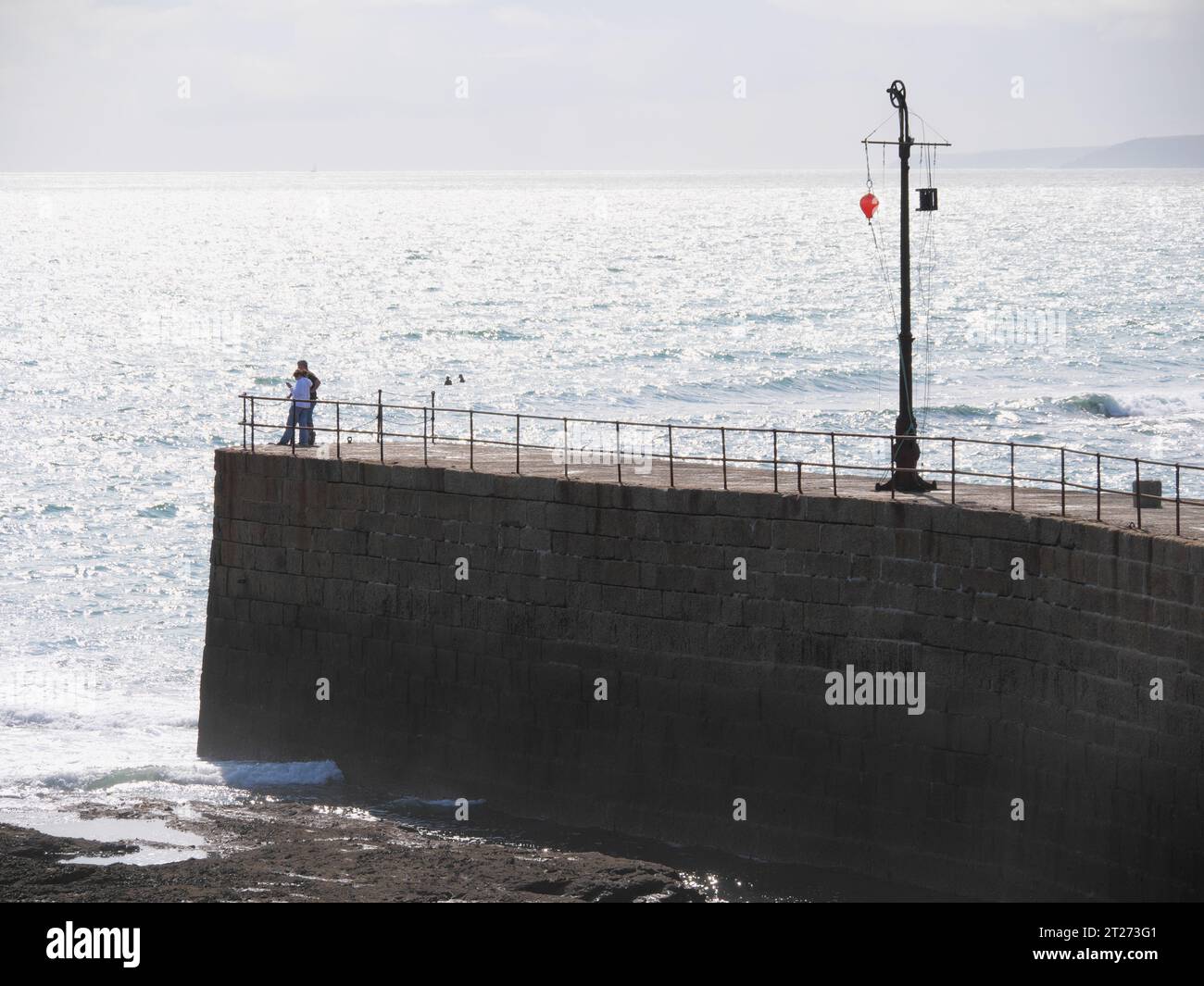 Abendstimmung am Pier mit Signalanlage im Hafen von Porthleven in Cornwall England Stockfoto