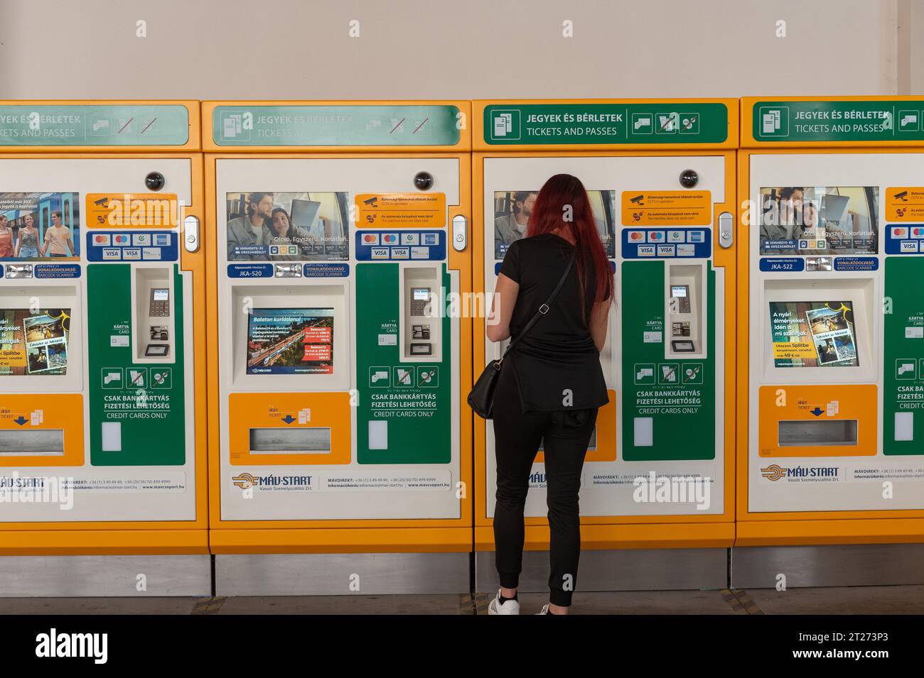 Budapest, Ungarn. 1. Oktober 2023 Eine Frau, die eine Zugfahrkarte an einem Automaten am Bahnhof Nyugati Palyaudvar in Budapest, Ungarn, kauft. Stockfoto