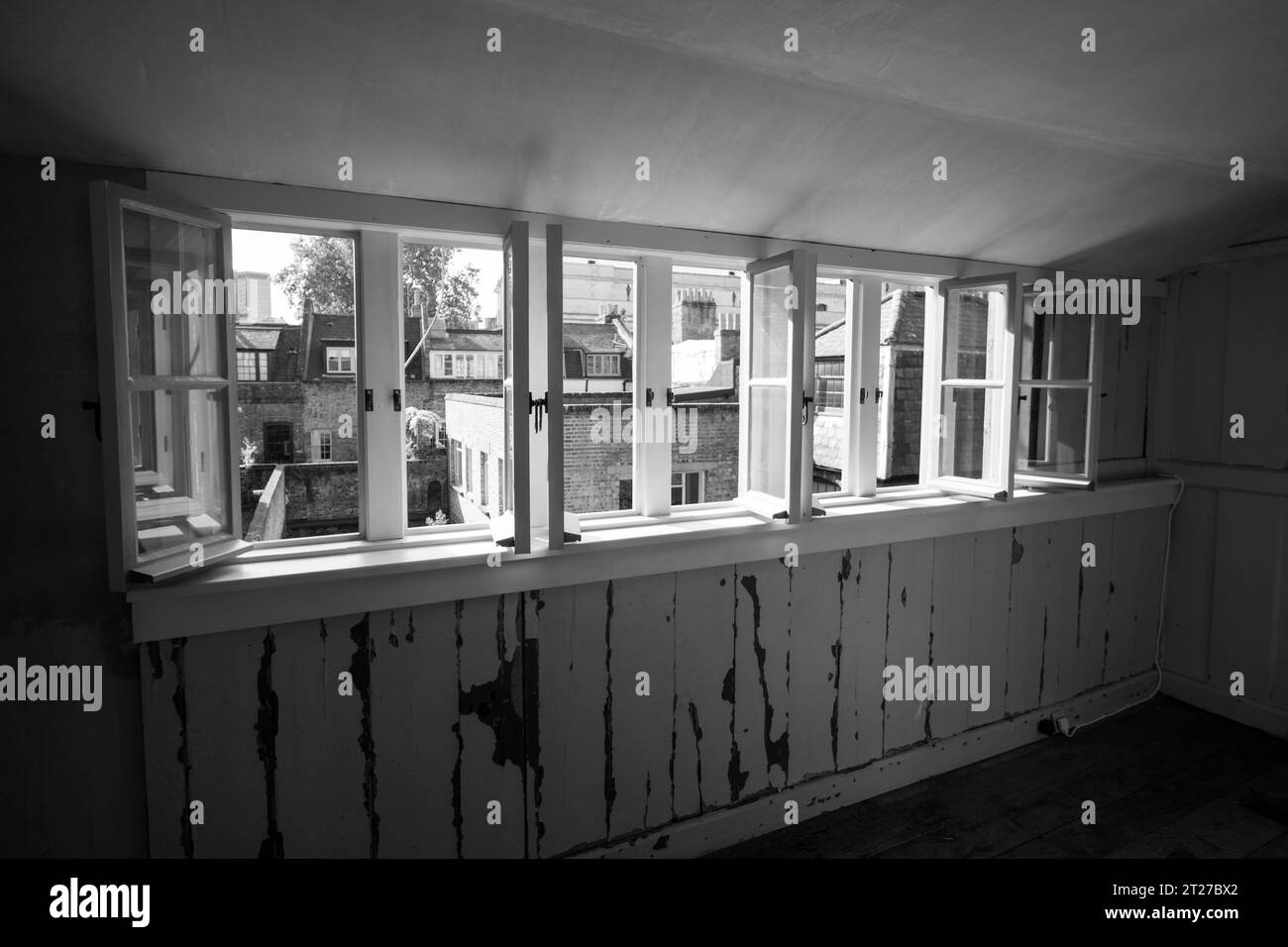 Blick durch die Fenster in der obersten Etage des verfallenen traditionellen georgianischen Hugenotten-Stadthauses in 4 Princelet Street, Spitalfields, London, Großbritannien. Stockfoto