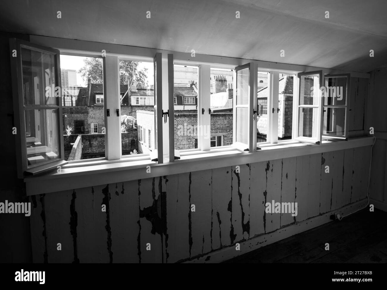 Blick durch die Fenster in der obersten Etage des verfallenen traditionellen georgianischen Hugenotten-Stadthauses in 4 Princelet Street, Spitalfields, London, Großbritannien. Stockfoto