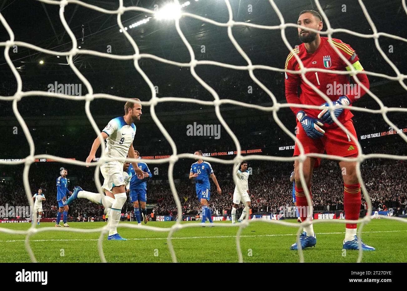 Der Englands Harry Kane (links) erzielt das erste Tor ihrer Mannschaft, während der italienische Torhüter Gianluigi Donnarumma während des Qualifikationsspiels zur UEFA Euro 2024 im Wembley Stadium, London, frustriert aussieht. Bilddatum: Dienstag, 17. Oktober 2023. Stockfoto