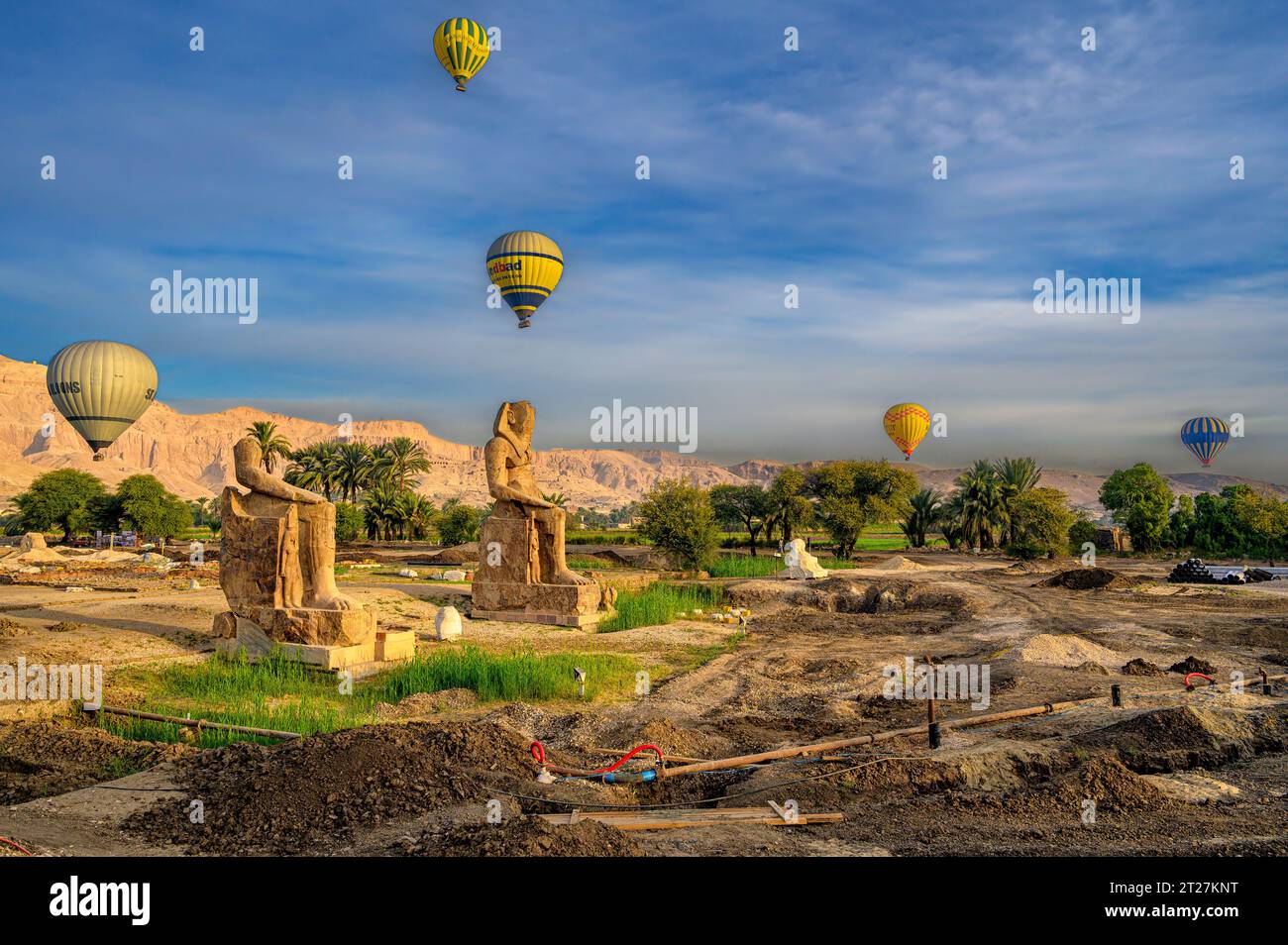 Heißluftballons fliegen über die Statuen der kolosse von KOM El Hitan in der Nähe des zweiten Pylons des Totentempels von Amenhotep III Stockfoto