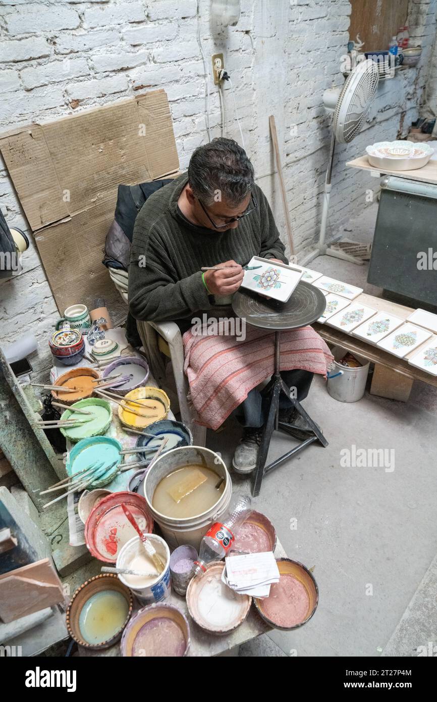 Ein mexikanischer Handwerker malt Keramikplatten in der Keramikwerkstatt Gorky Gonzales in Guanajuato, Mexiko. Die Werkstatt rettete traditionelle Majolika-Töpferwaren, die in der Zeit verloren gegangen waren. Stockfoto