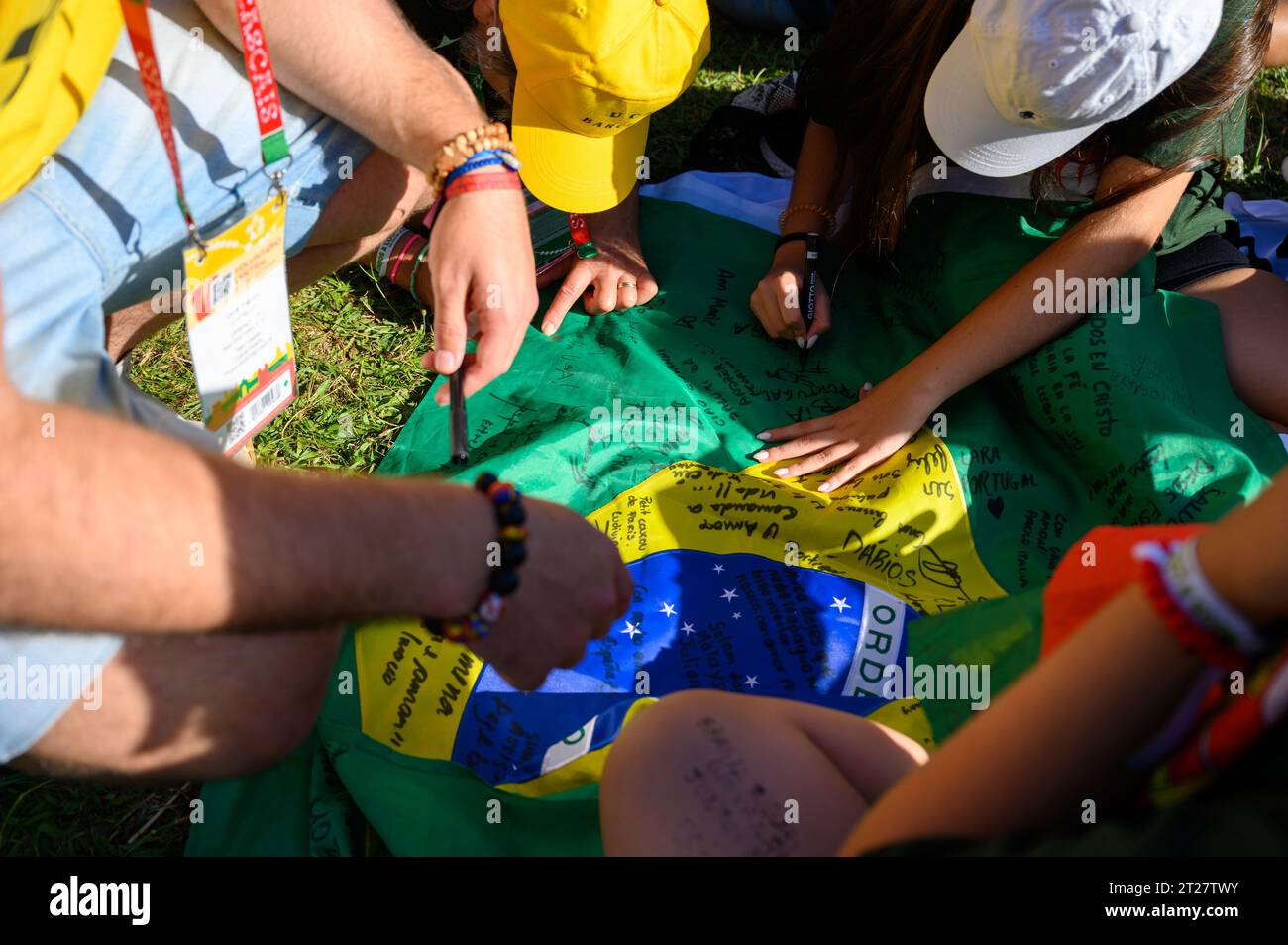 Pilger, die eine brasilianische Flagge als Andenken unterzeichnen. Die Eröffnungszeremonie der Weltjugendtage 2023 in Lissabon, Portugal. Stockfoto