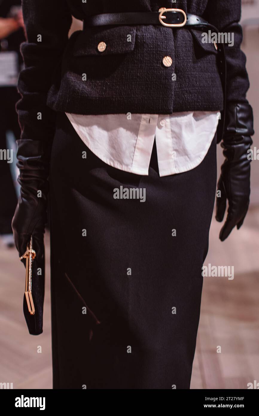 Klassische schwarze Jacke, Ledergürtel, Handschuhe und klassische Samtschuppe. Modemodell posiert auf der Backstage Stockfoto