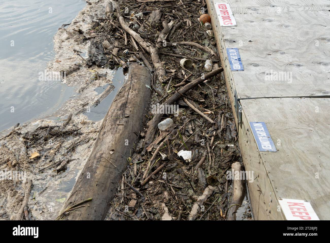 Müll und Verschmutzung sammeln sich an einem Dock in einem Fluss Stockfoto