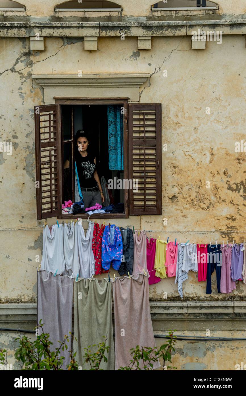 Blick von der Stadtmauer Spaziergang einer Frau in einem Fenster und Trocknen der Wäsche in der Altstadt von Dubrovnik in Südkroatien. Stockfoto