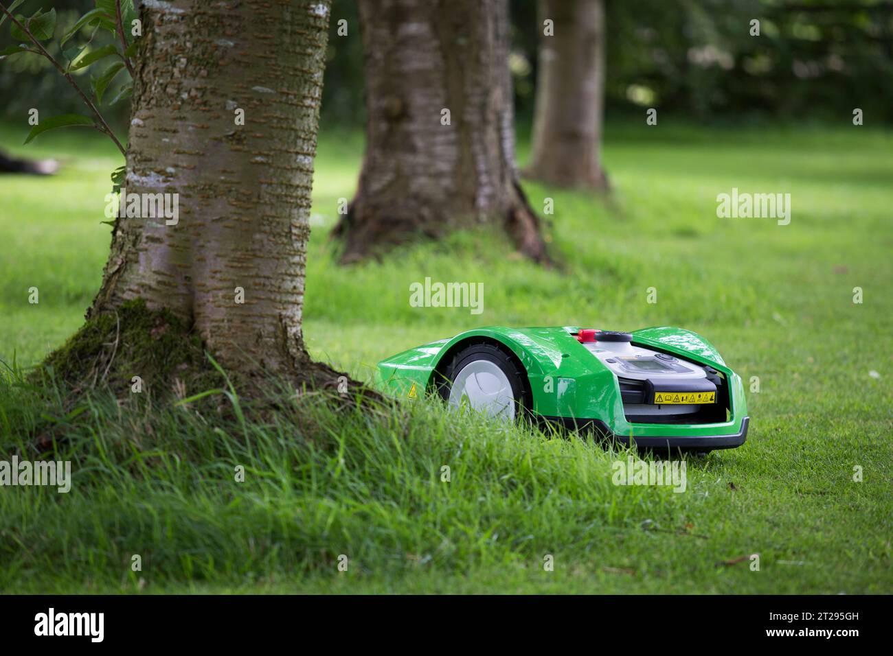 Ein automatisierter Rasenmäher, der Hindernisse in einem Garten in Großbritannien überwindet. Stockfoto