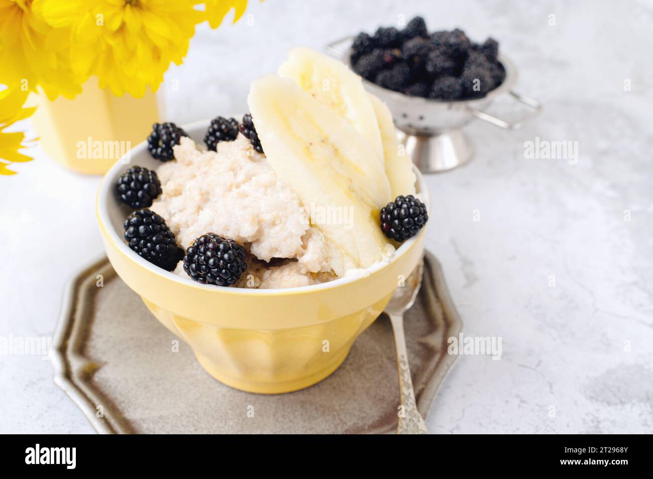 Haferbrei zum Frühstück. Gesundes Frühstück mit Haferflocken, Bananen, Brombeeren und Maulbeeren. Stockfoto