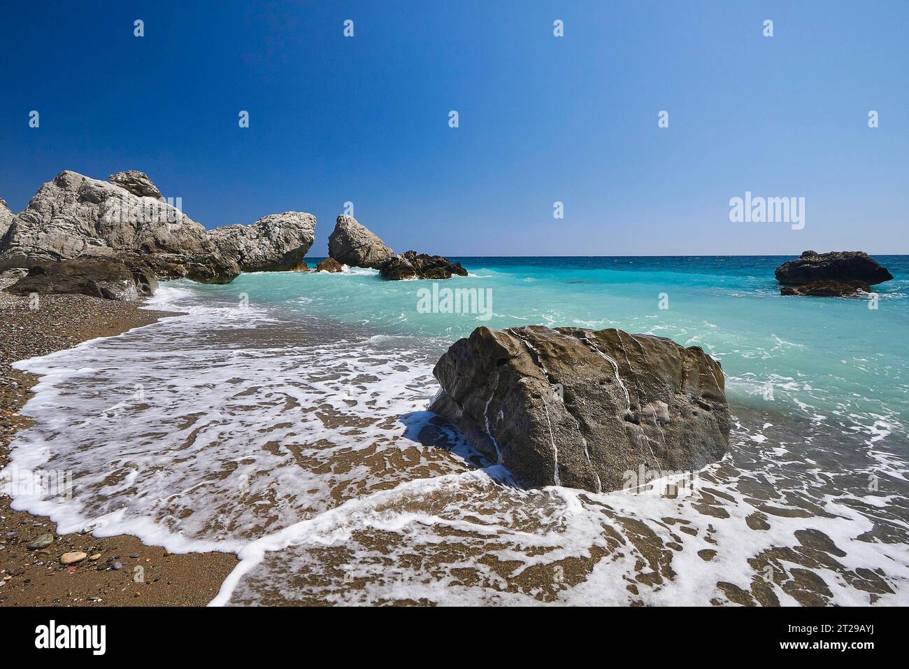 Strand, Südküste, grünes Meer, Brandung, blauer wolkenloser Himmel, Felsen im Meer, in der Nähe von Mirtos, Provinz Lassithi, Kreta, Griechenland Stockfoto