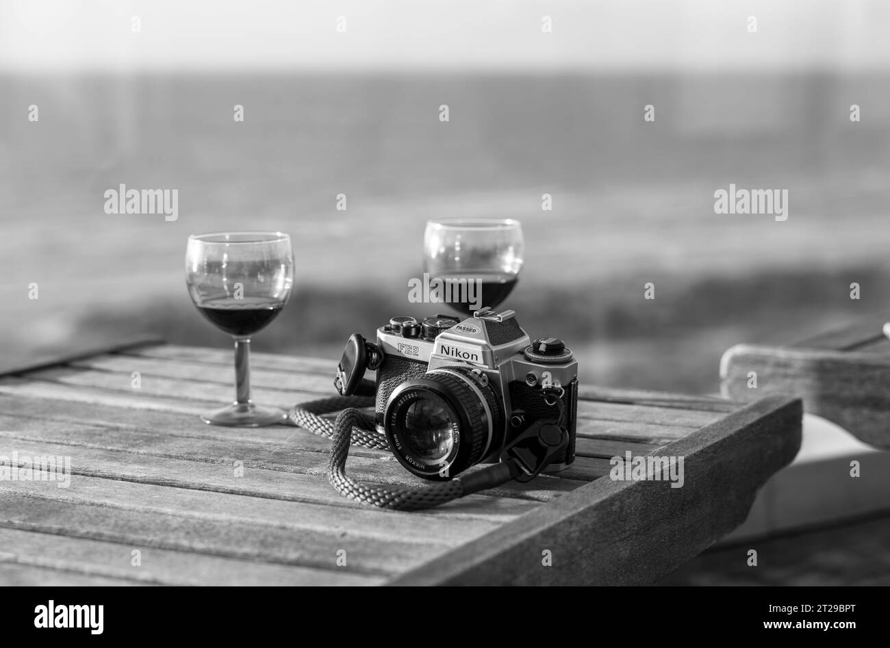 Analoge Nikon Kamera FE2 und Rotweingläser auf der Terrasse, de Panne, de Panne, Flandern, Belgien Stockfoto