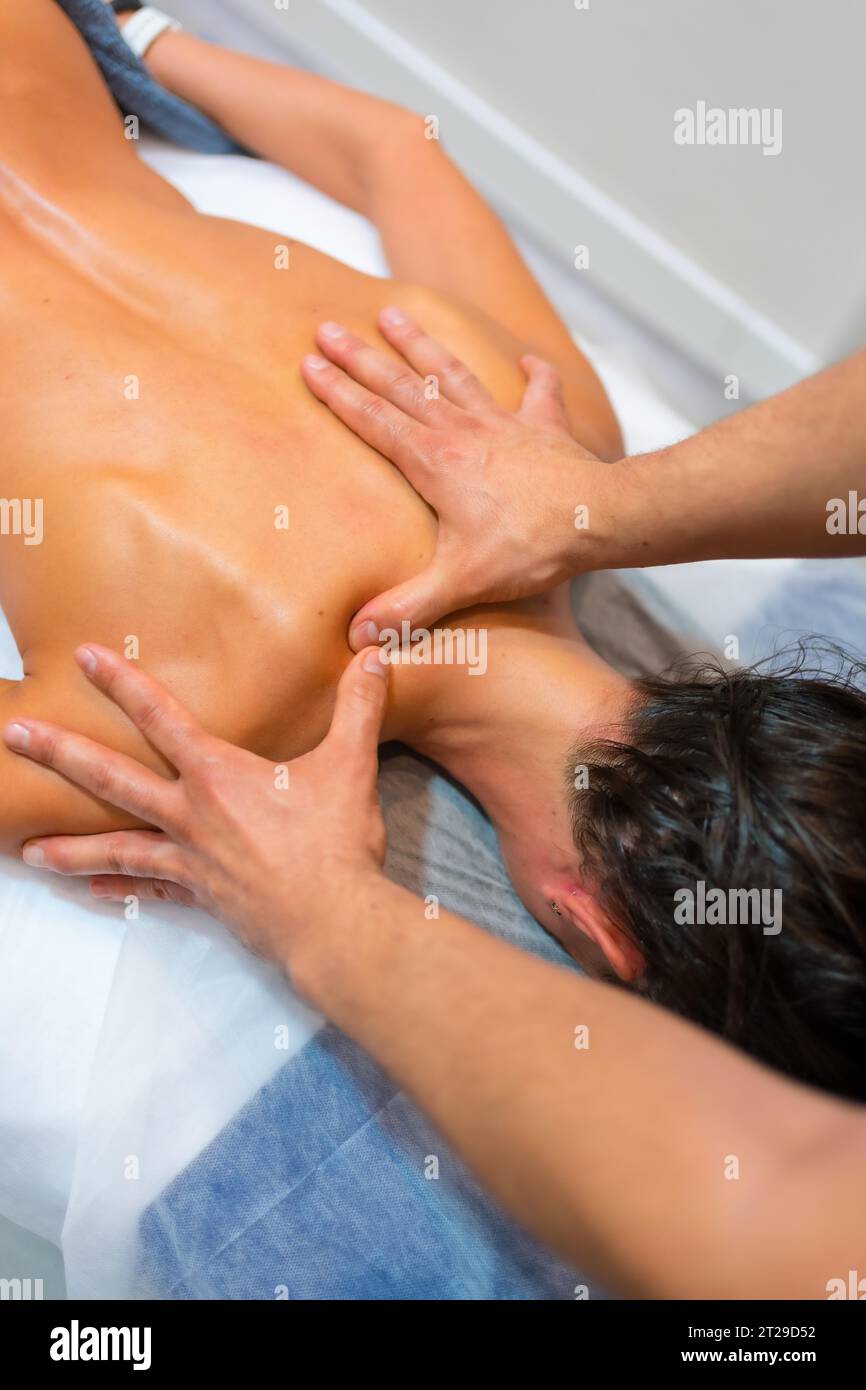 Physiotherapeutische Massage einer nicht erkennbaren Frau, die mit Fingern auf einer Bahre auf ihrem Rücken liegt Stockfoto