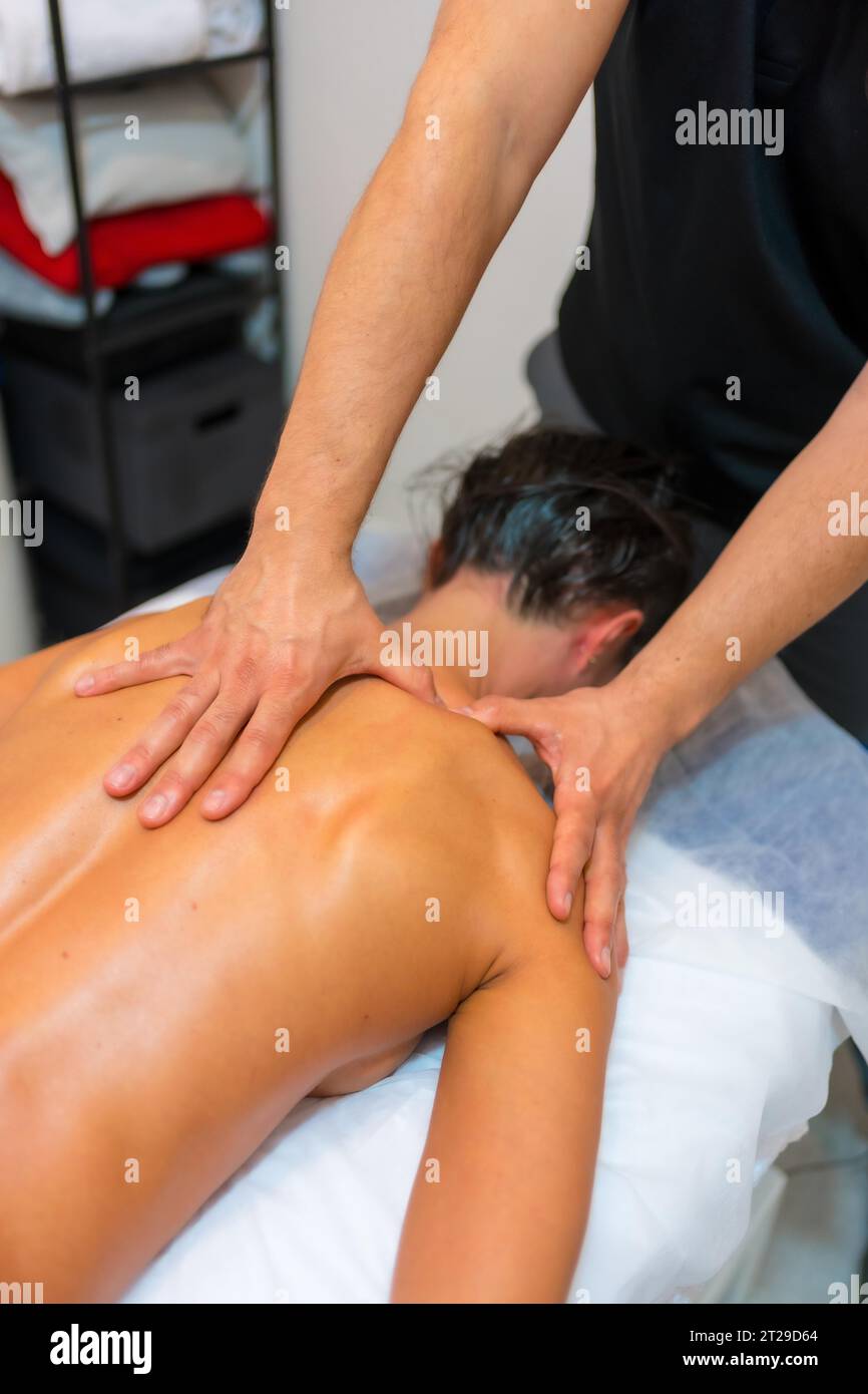 Physiotherapeutische Massage einer nicht erkennbaren Frau, die mit Fingern auf einer Bahre auf ihrem Rücken liegt Stockfoto