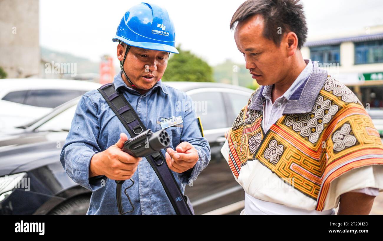 (231018) -- GUIYANG, 18. Oktober 2023 (Xinhua) -- Ein Mitarbeiter eines örtlichen öffentlichen Versorgungsunternehmens weist einen Bewohner an, eine Ladestation im Dorf Huiyi, Bezirk Zhongshan der Stadt Liupanshui, südwestchinesische Provinz Guizhou, zu benutzen, 22. September 2023. In den letzten Jahren hat die Guizhou Power Grid Co., Ltd. Von China Southern Power Grid mit großem Engagement daran gearbeitet, das Ladenetz für neue Energiefahrzeuge auf den ländlichen Raum auszudehnen. Dank gut abgestimmter Bemühungen, die Nachfrage der Öffentlichkeit nach umweltfreundlichem Transport in der vollständig zu decken, sind jetzt in jedem Township in Guizhou Ladungspfähle verfügbar Stockfoto