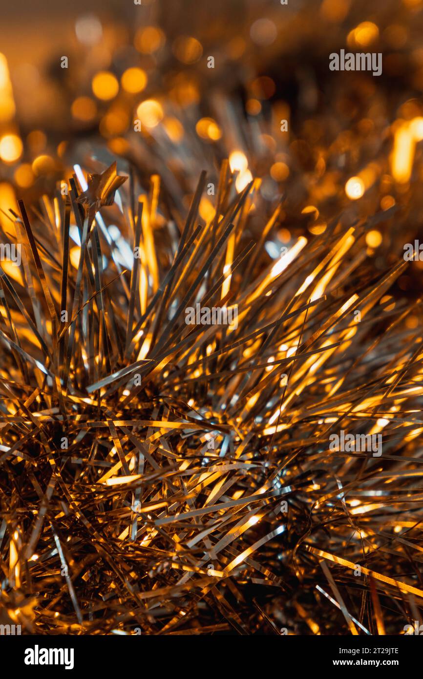 Detail einer Lametta-Girlande aus Gold und Silber. Weihnachtsdekoration. Nahaufnahme. Selektiver Fokus Stockfoto