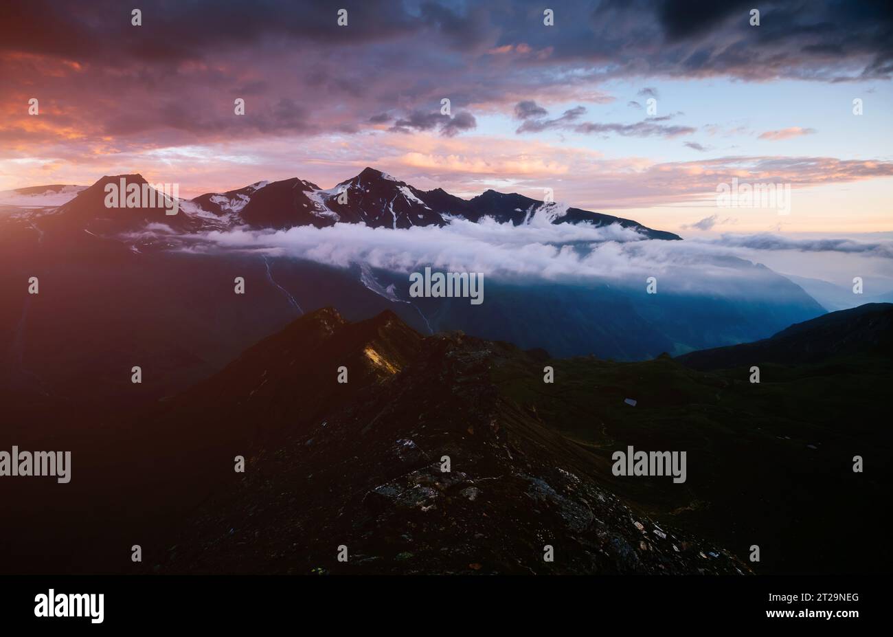 Ein Blick auf die sonnenbeschienenen Hügeln in der Dämmerung. Dramatische Abend Szene. Ort Großglockner Hochalpenstraße, Österreich. Europa. Klimawandel. Bevölkerung Stockfoto