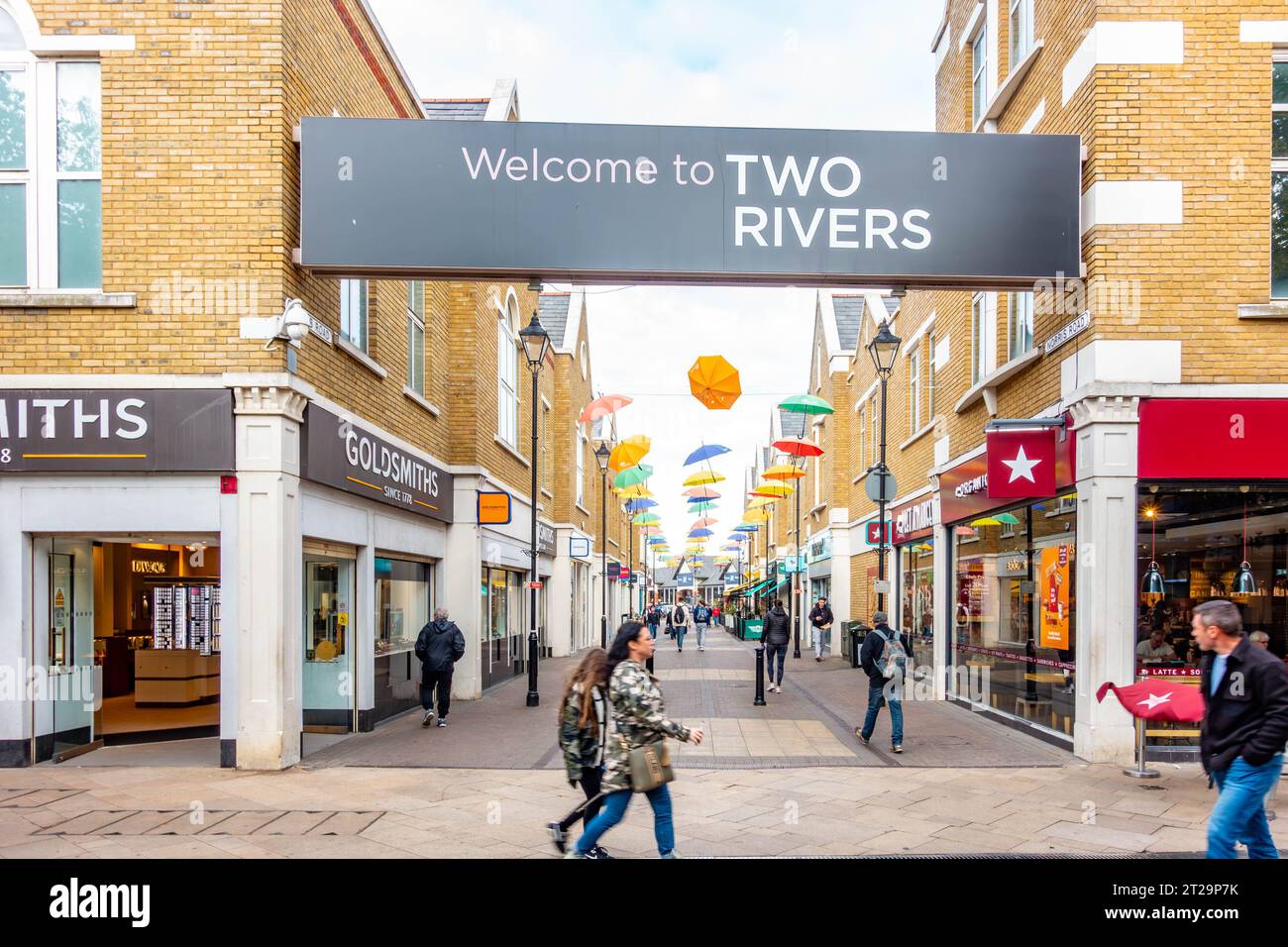 Eintritt in die Two Rivers-Gegend von Staines-upon-Thames in Surrey, Großbritannien, mit einem großen Begrüßungsschild über den Köpfen der Menschen Stockfoto