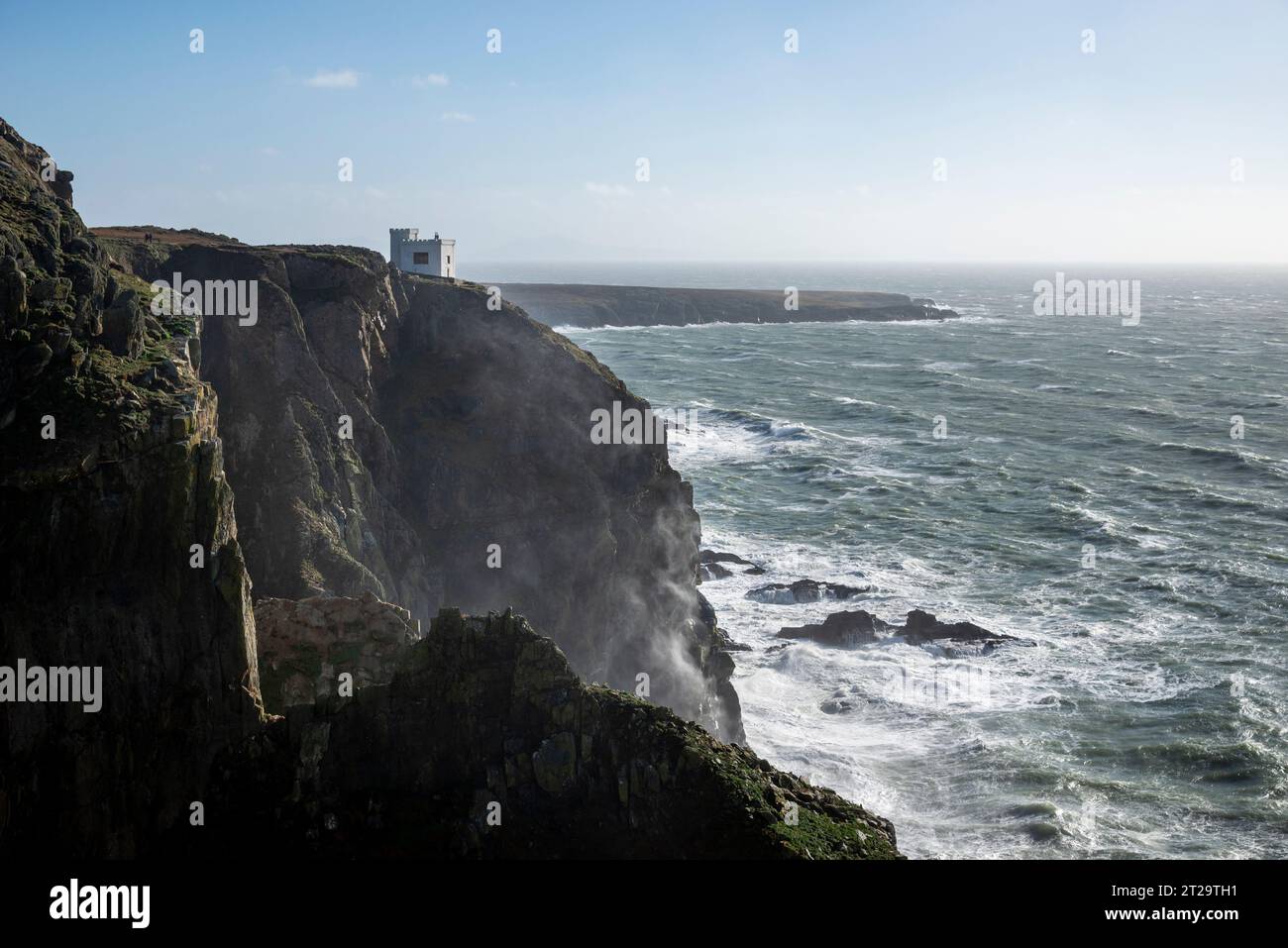 Elin's Tower eine Torheit am Rande der dramatischen Klippen in South Stack, Anglesey, Nordwales. Ein windiger Herbsttag mit Wellen, die gegen Felsen krachen. Stockfoto